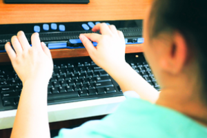persoon bedient een brailleleesregel