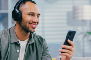 jongeman met koptelefoon en mobiel in de hand