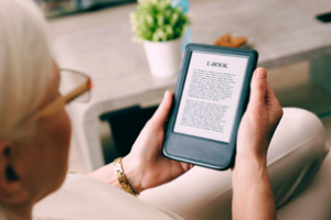 persoon houdt ipad vast waarop een e-book te zien is