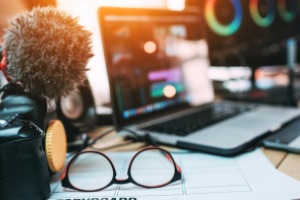 beeldschermen, microfoon en opname-apparatuur, bril op bureau